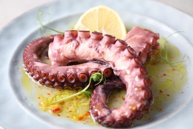 Photo of Appetizing octopus tentacles on table, closeup view