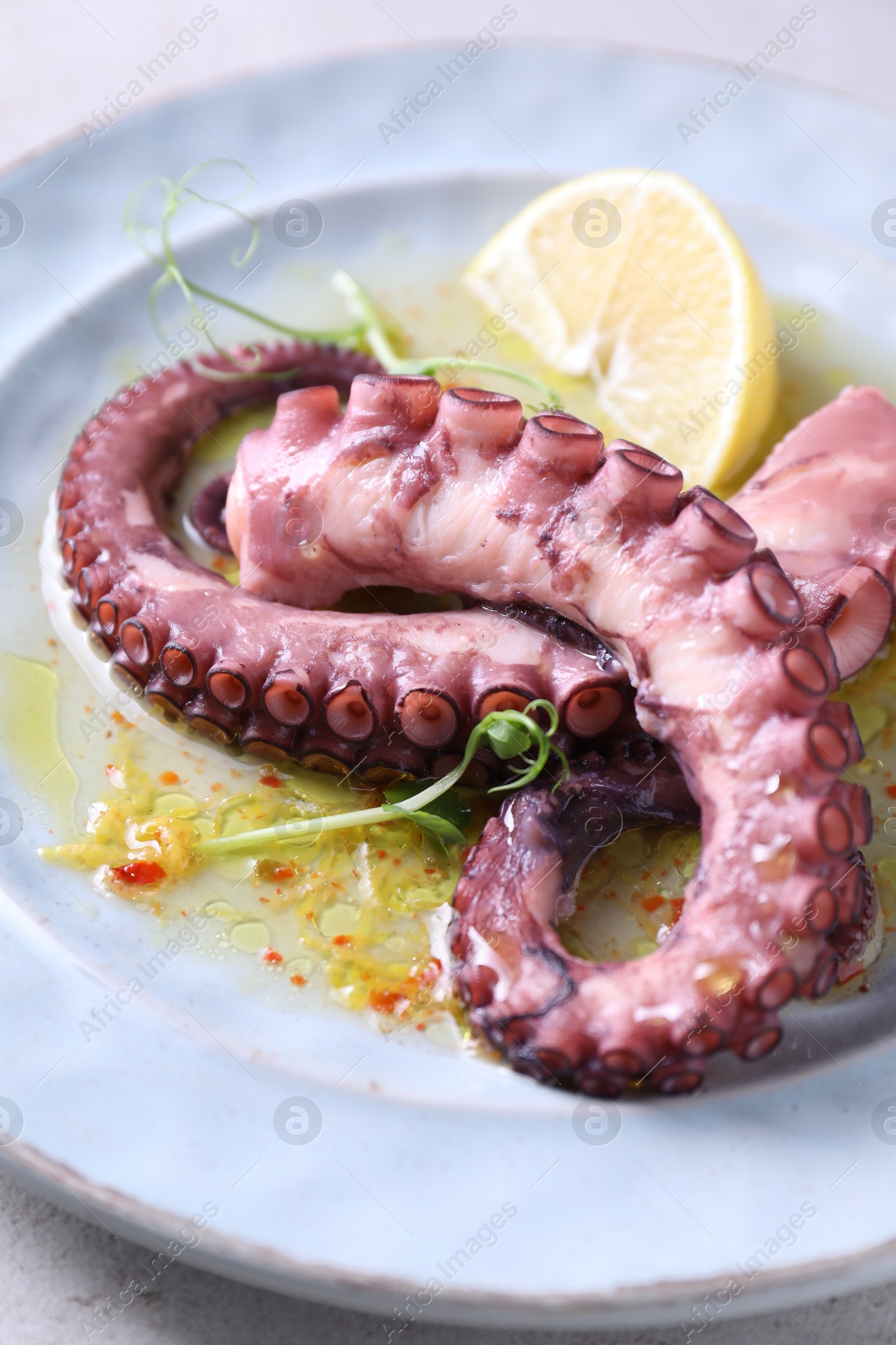 Photo of Appetizing octopus tentacles on light table, closeup