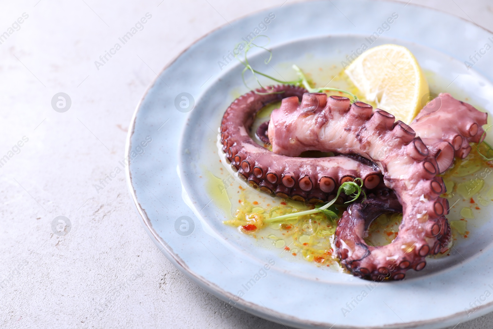 Photo of Appetizing octopus tentacles on light table, closeup