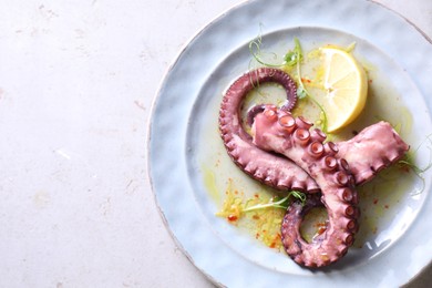 Photo of Appetizing octopus tentacles on light table, top view