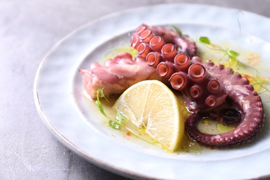 Photo of Appetizing octopus tentacles on light table, closeup