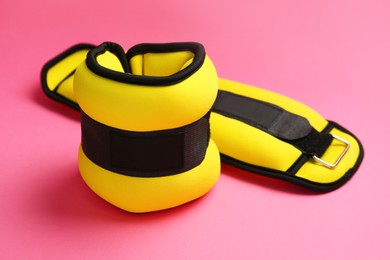 Photo of Stylish yellow ankle weights on pink background