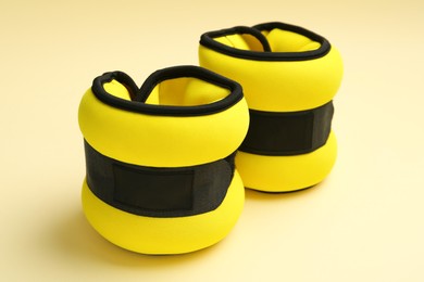 Photo of Stylish yellow ankle weights on beige background