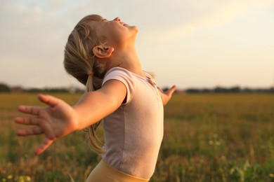 Photo of Cute little girl at meadow. Child enjoying beautiful nature