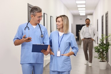 Healthcare workers with clipboard talking in hospital