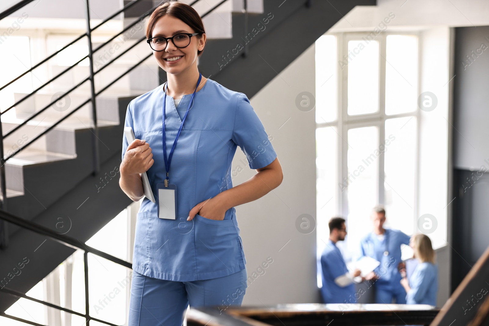 Photo of Smiling healthcare worker with tablet in hospital