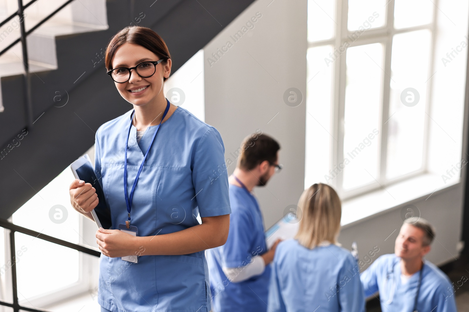 Photo of Smiling healthcare worker with tablet in hospital