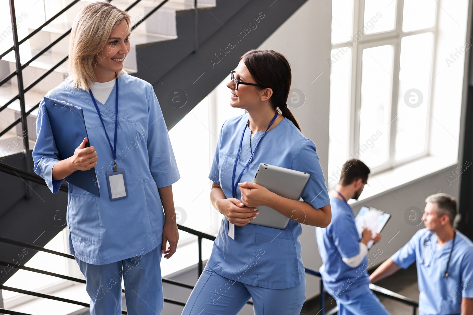 Photo of Healthcare workers in hospital, selective focus. Nurses with clipboard and tablet indoors