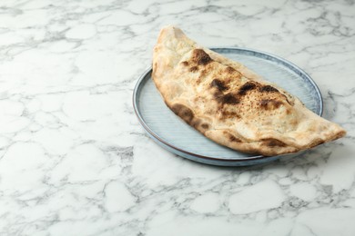 Delicious calzone on white marble table. Space for text