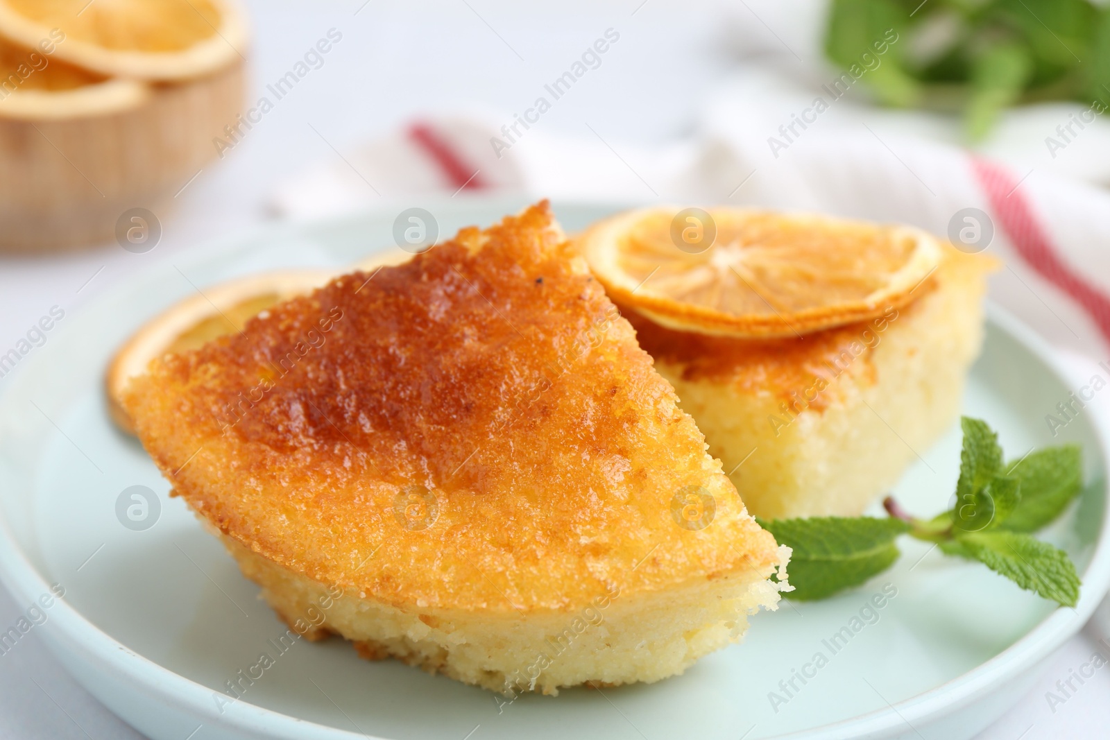 Photo of Tasty semolina cake served on white tiled table, closeup