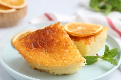 Tasty semolina cake served on white tiled table, closeup