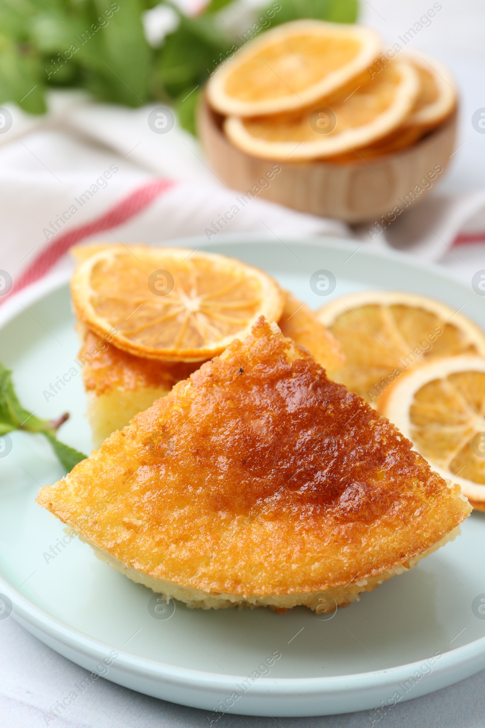 Photo of Tasty semolina cake served on white tiled table, closeup