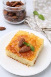 Photo of Slice of tasty semolina cake served on white tiled table, closeup