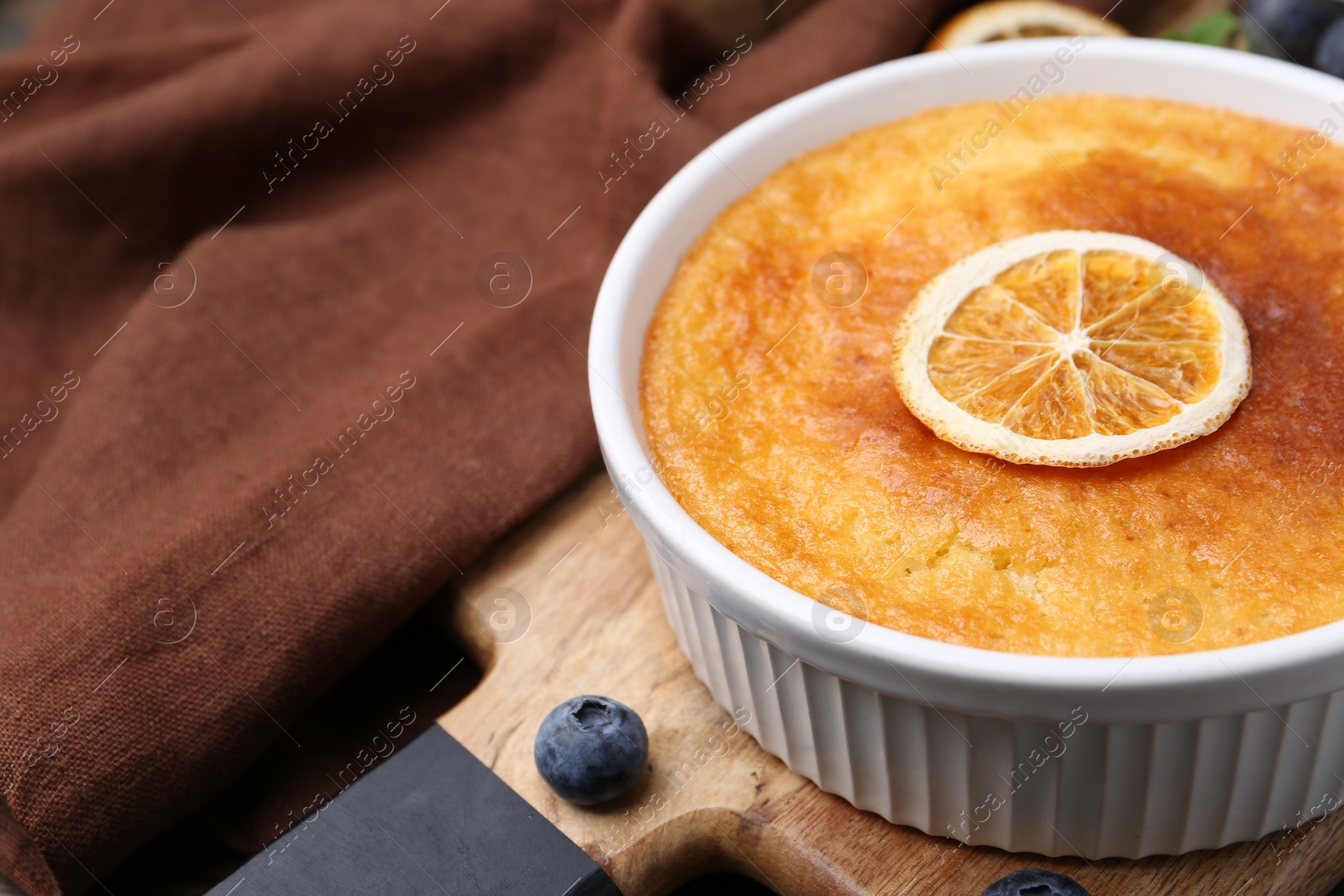 Photo of Tasty semolina cake served on wooden table, closeup. Space for text