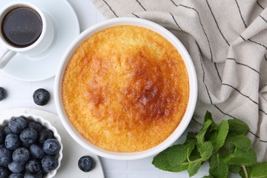 Photo of Tasty semolina cake served on white tiled table, flat lay