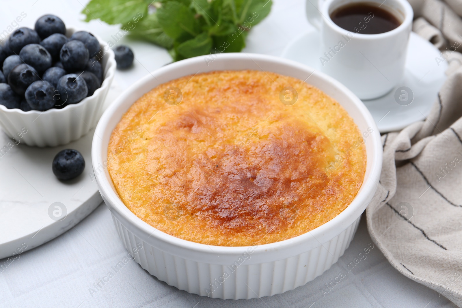 Photo of Tasty semolina cake served on white tiled table, closeup