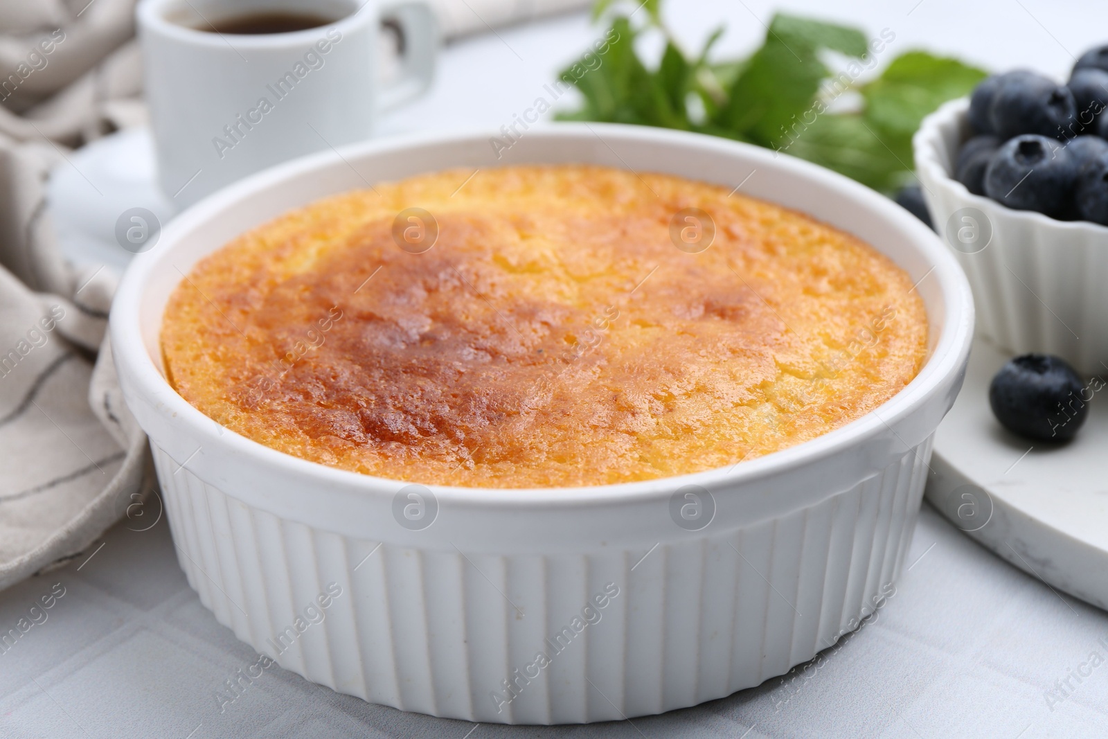 Photo of Tasty semolina cake served on white tiled table, closeup