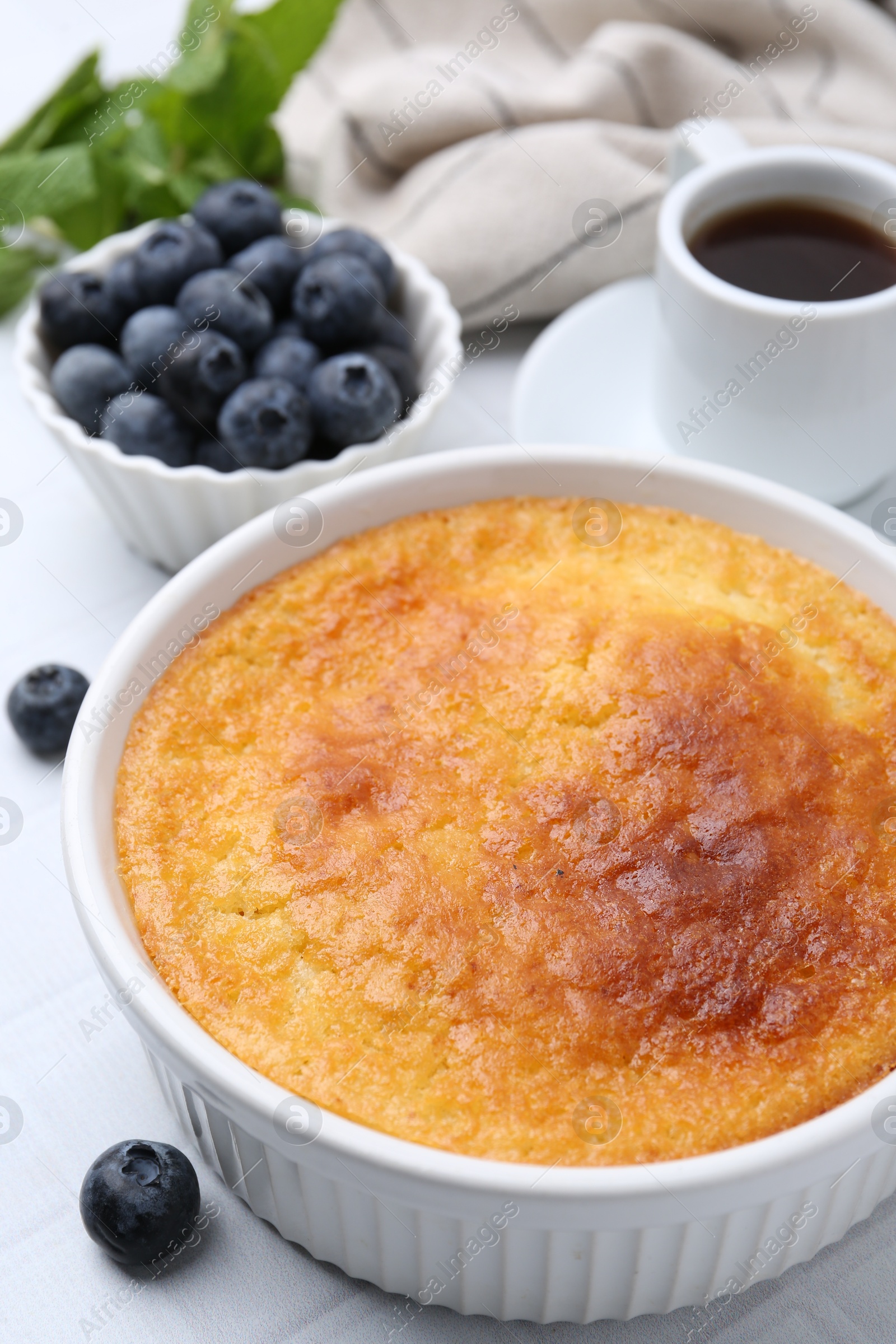 Photo of Tasty semolina cake served on white tiled table, closeup