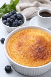 Photo of Tasty semolina cake served on white tiled table, closeup