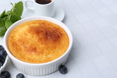 Tasty semolina cake served on white tiled table, closeup. Space for text