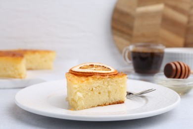 Photo of Slice of tasty semolina cake served on white table, closeup