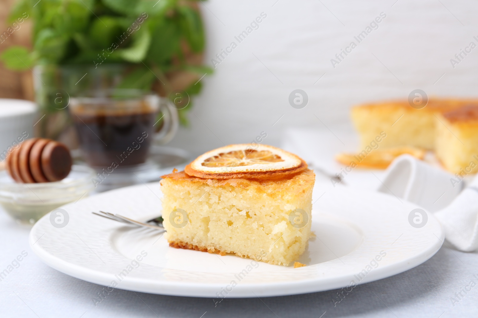 Photo of Slice of tasty semolina cake served on white table, closeup