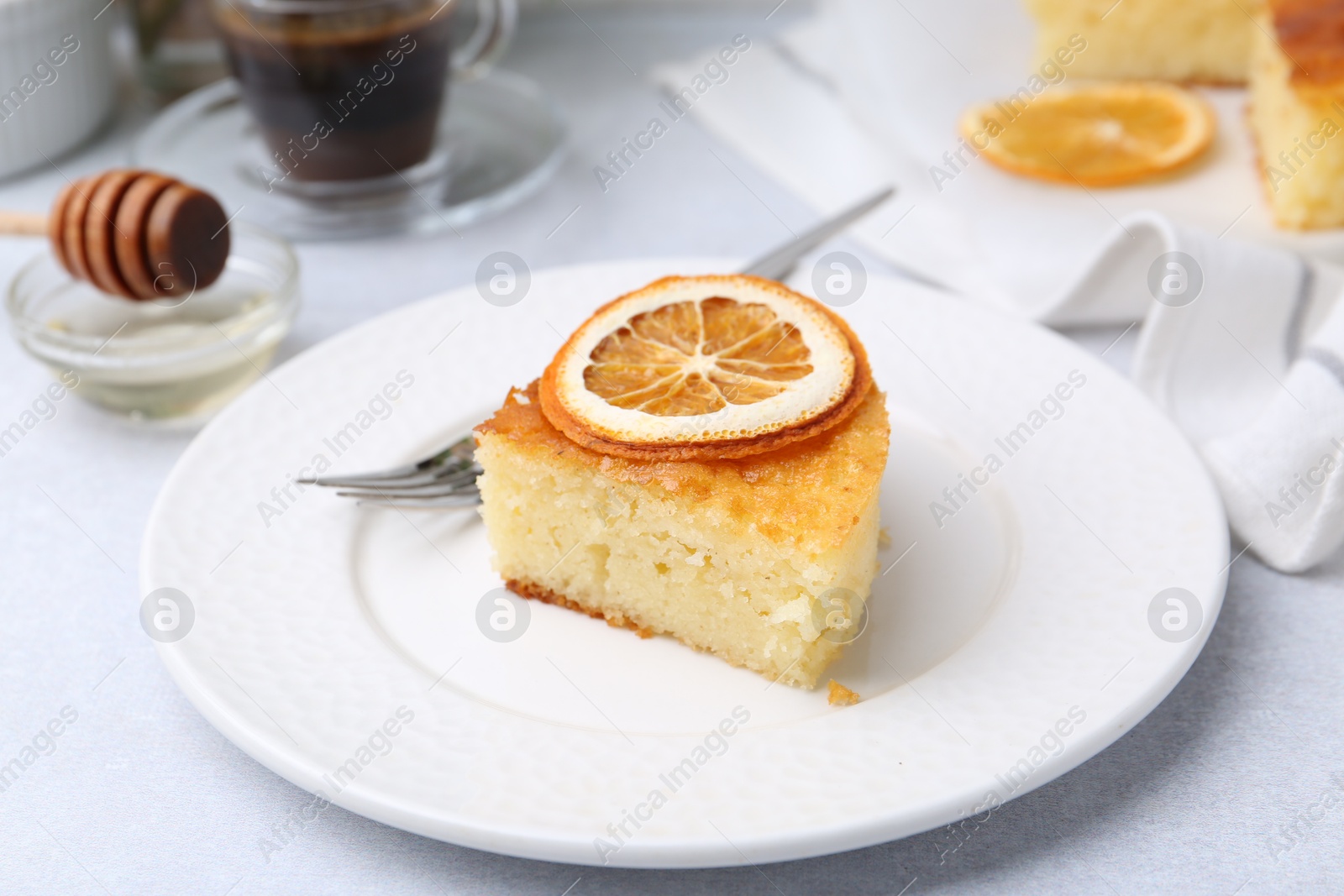 Photo of Slice of tasty semolina cake served on white table, closeup