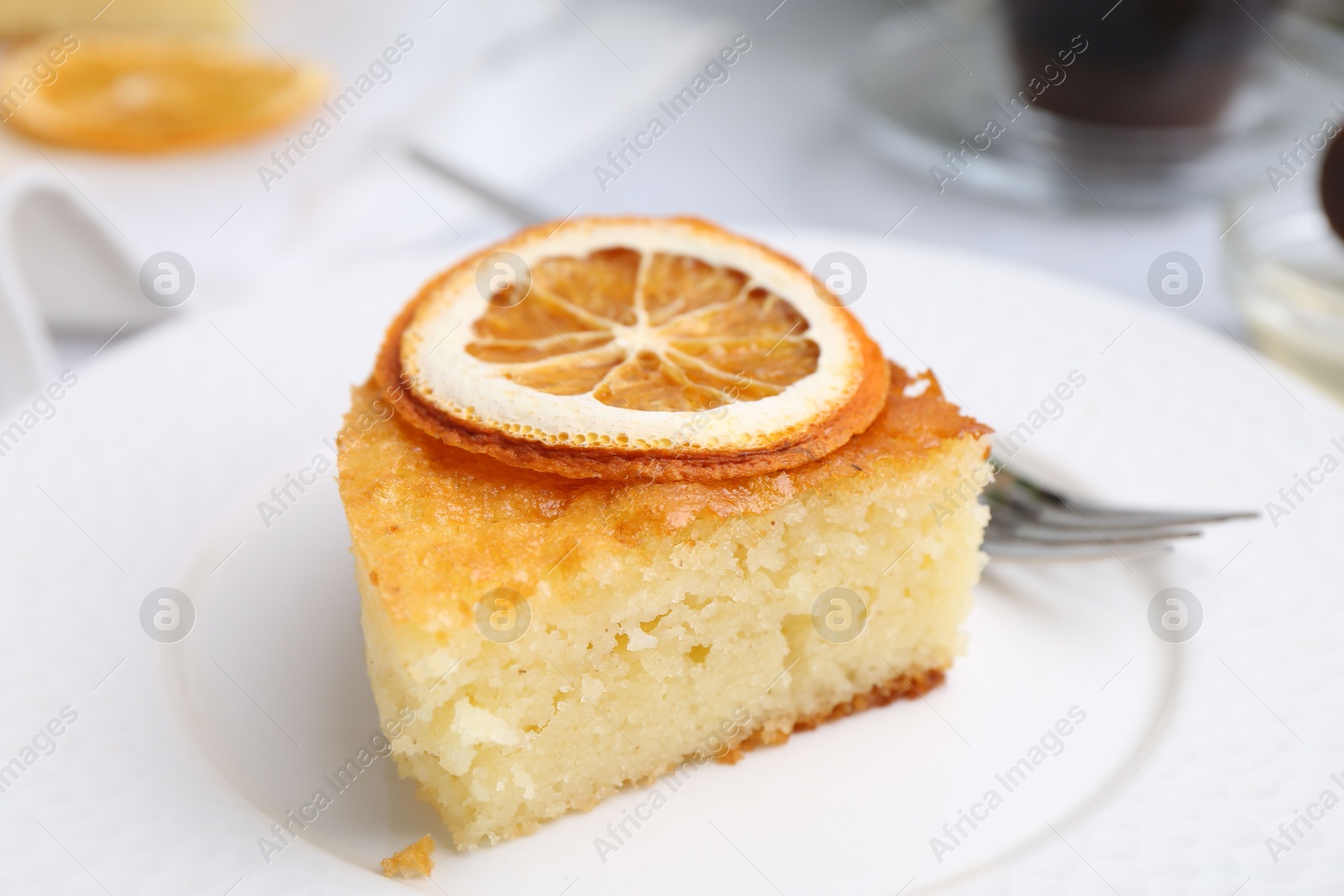 Photo of Slice of tasty semolina cake served on white table, closeup