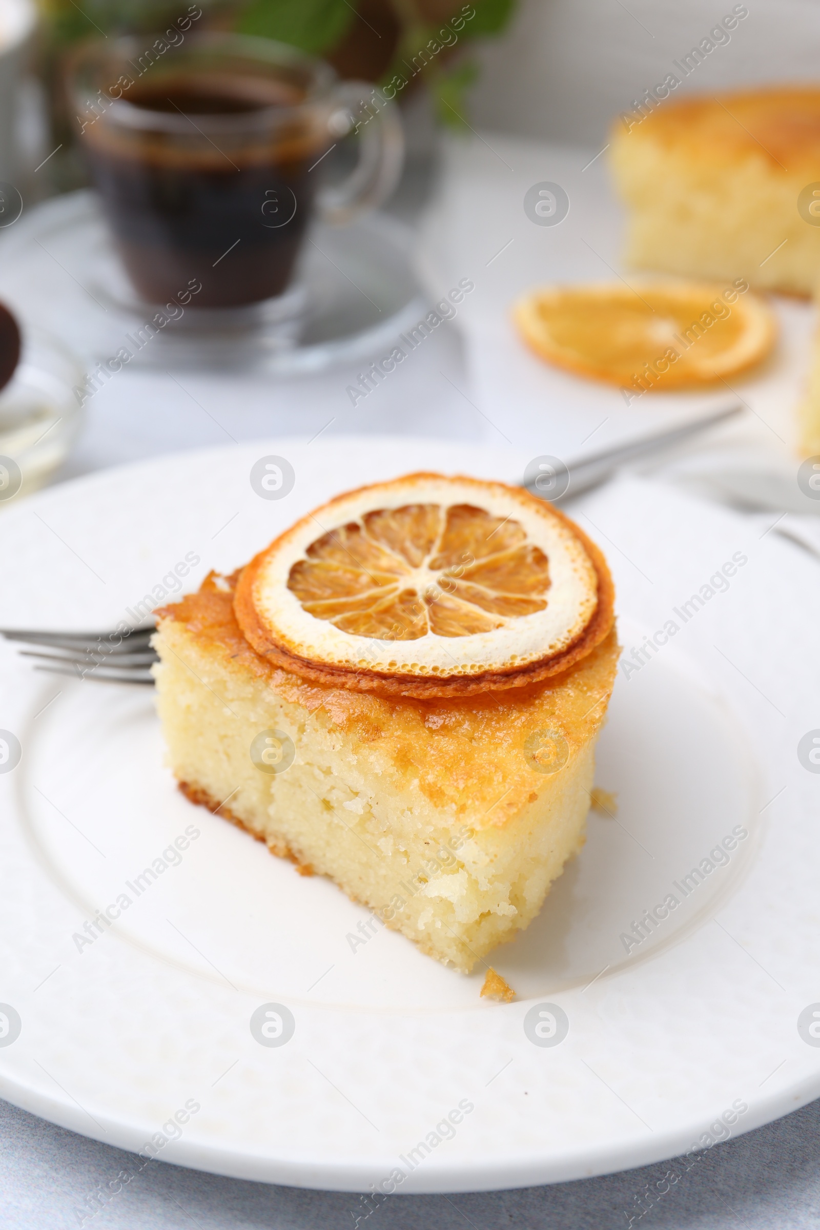 Photo of Slice of tasty semolina cake served on white table, closeup