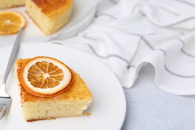 Photo of Slice of tasty semolina cake served on white table, closeup. Space for text