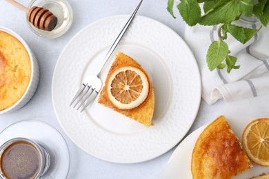 Photo of Slice of tasty semolina cake served on white table, flat lay