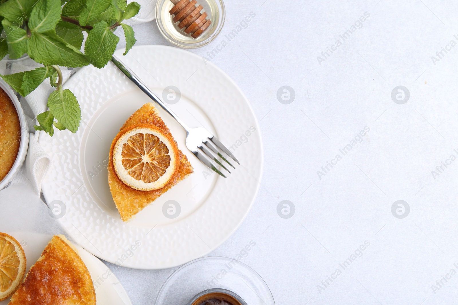 Photo of Slice of tasty semolina cake served on white table, flat lay. Space for text