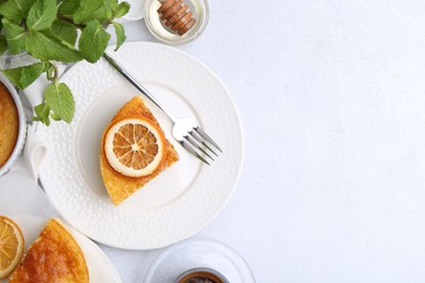 Photo of Slice of tasty semolina cake served on white table, flat lay. Space for text