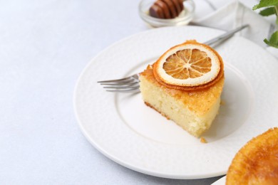 Photo of Slice of tasty semolina cake served on white table, closeup. Space for text