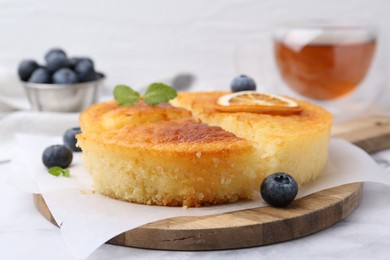 Photo of Tasty semolina cake served on white marble table, closeup