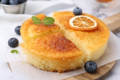 Photo of Tasty semolina cake served on white marble table, closeup