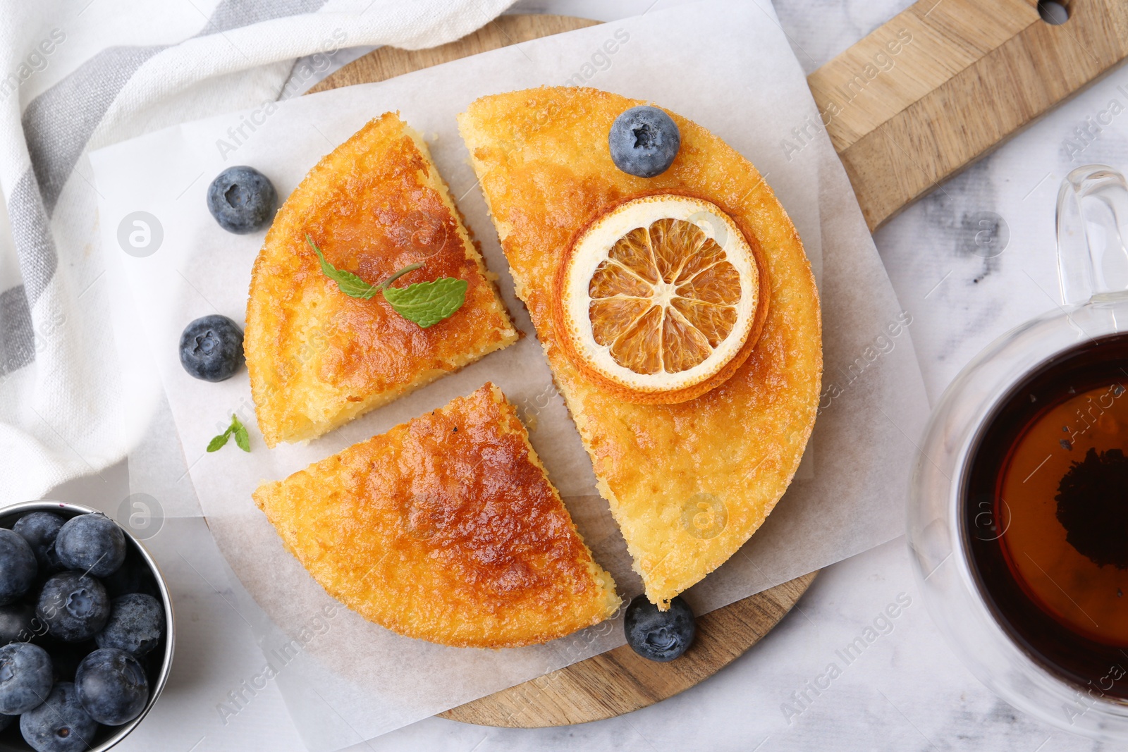 Photo of Tasty semolina cake served on white marble table, flat lay