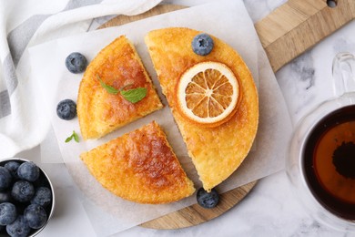 Photo of Tasty semolina cake served on white marble table, flat lay