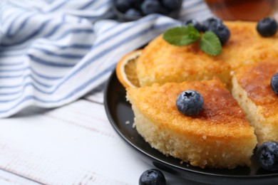 Photo of Delicious semolina cake with blueberries on white wooden table, closeup. Space for text