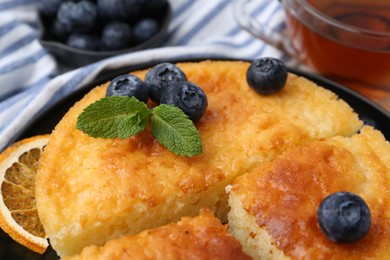 Photo of Delicious semolina cake with blueberries and orange slices on table