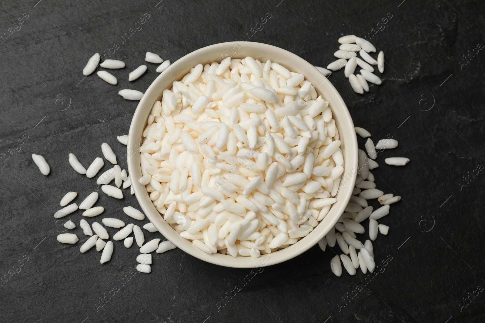 Photo of Puffed rice in bowl on dark table, top view