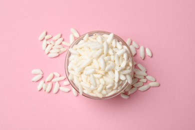 Photo of Puffed rice in bowl on light pink background, top view