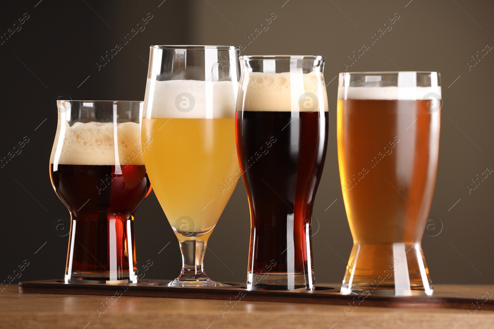 Photo of Glasses with different types of beer on wooden table indoors, closeup