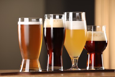 Photo of Glasses with different types of beer on wooden table indoors, closeup