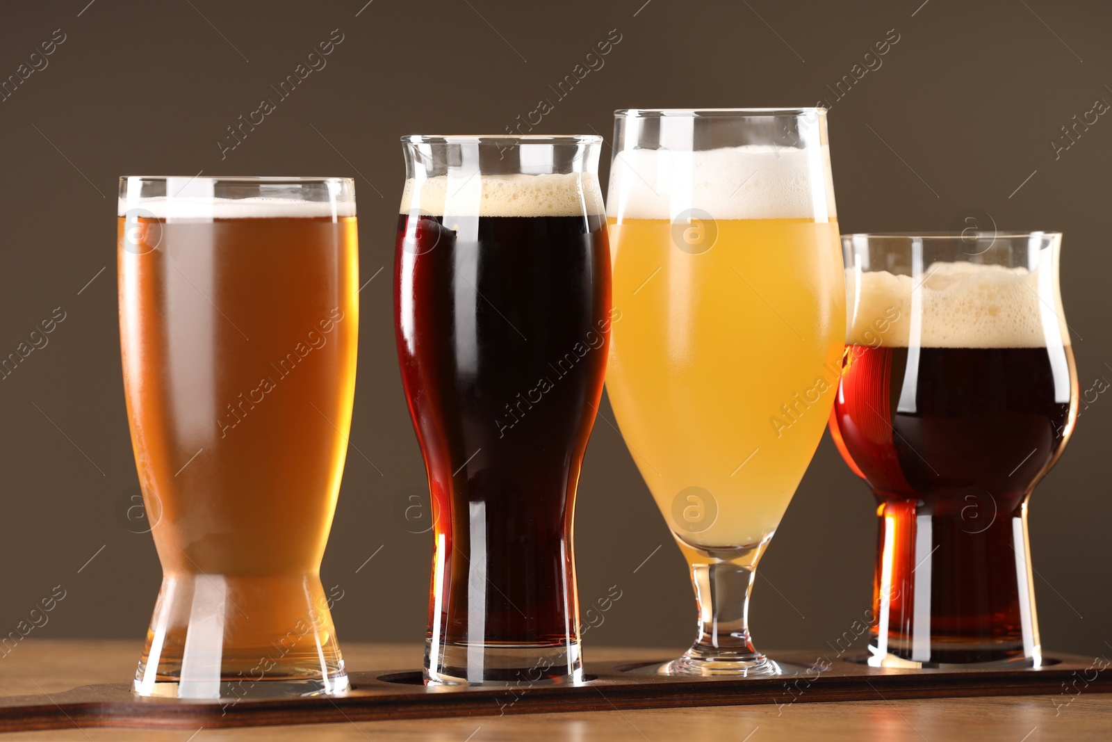 Photo of Glasses with different types of beer on wooden table indoors, closeup