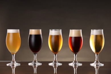 Photo of Glasses with different types of beer on mirror surface