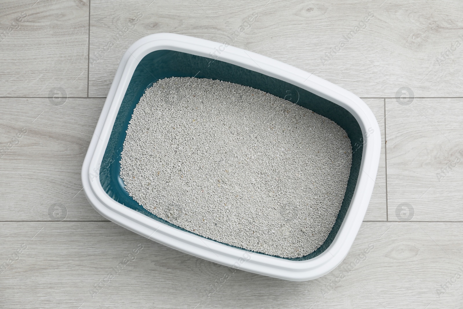 Photo of Cat tray with clumping litter on floor indoors, top view