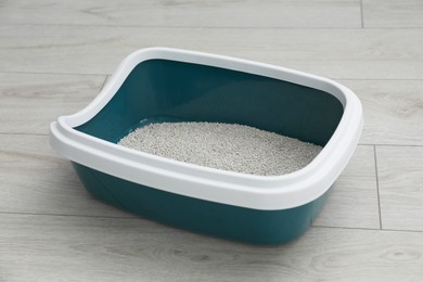 Photo of Cat tray with clumping litter on floor indoors