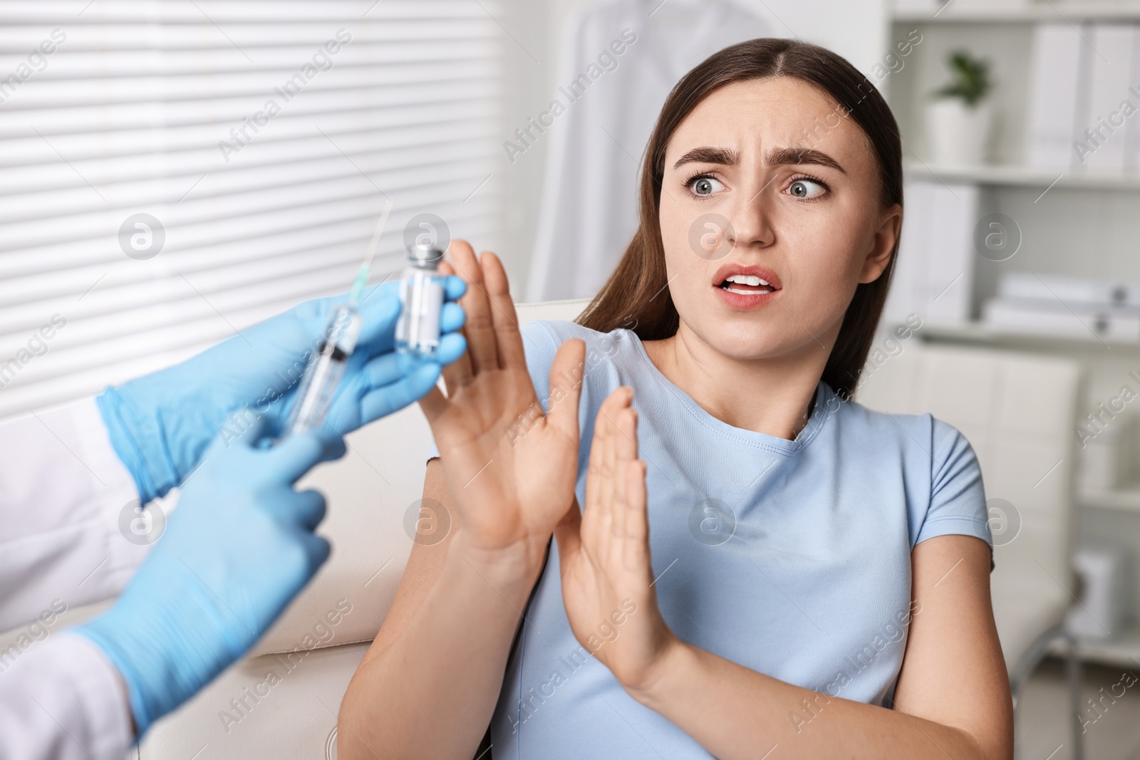 Photo of Dental phobia. Dentist with syringe and vial near scared woman in clinic, closeup