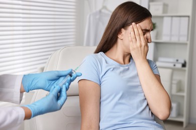 Dental phobia. Dentist with syringe near scared woman in clinic, closeup